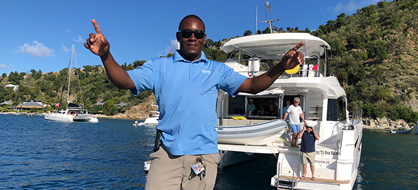 MarineMax Vacations team member standing in front of a MarineMax charter