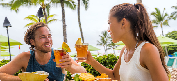 A couple at an outdoor restaurant with drinks and food