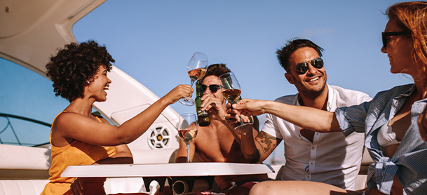 Four people aboard a yacht clinking glasses