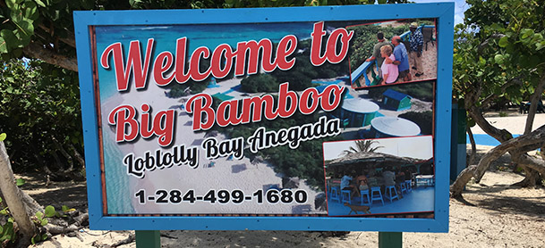 A sign saying Welcome to Big Bamboo Loblolly Bay Anegada, placed on a beach in the BVI