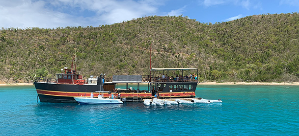 The Willy T floating bar, a black vessel anchored near the coast of the British Virgin Islands