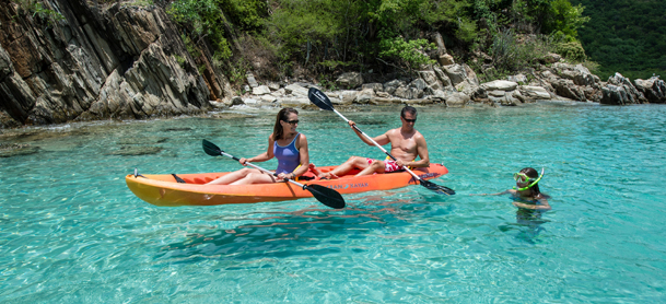 Man and woman kayaking with girl in the water snorkeling