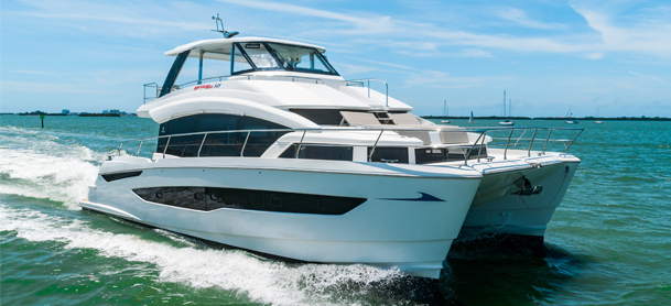 A sleek white catamaran sails swiftly across turquoise waters under a clear blue sky, conveying a sense of luxury and adventure.
