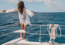 woman with arms out looking out on the water