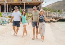 group of four walking together on a beach