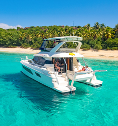 MarineMax BVI Vacations Power Catamaran on the clear blue water next to the island