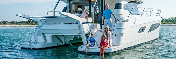 family on aft of aquila 44 power catamaran during charter trip