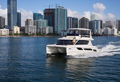 boat cruising in front of a big city