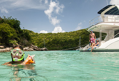 A girl snorkeling while her parents watch from a boat