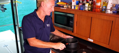 Man cooking on power catamaran