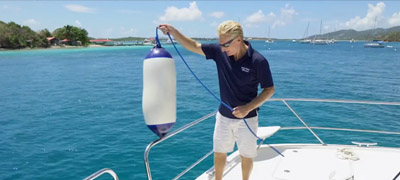 Man tying on a boat fender