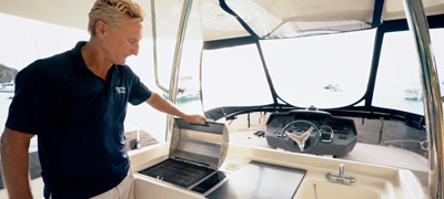 Man showing grill on flybridge on power catamaran