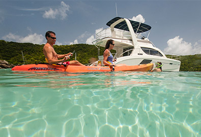 Couple on kayaks next to their charter boat