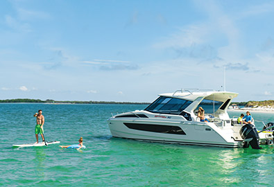 man paddle boarding by an anchored boat