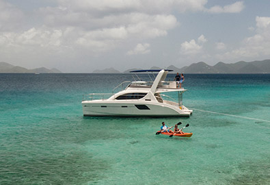 people kayaking by a yacht