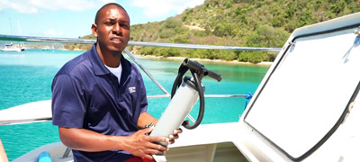 Man holding water pump aboard boat