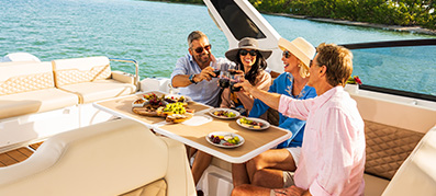 People raising glasses while eating aboard a boat