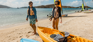 two people on the beach with kayaks