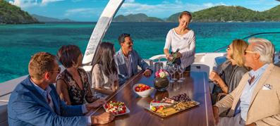 group of people sitting at a table on charter with crew member