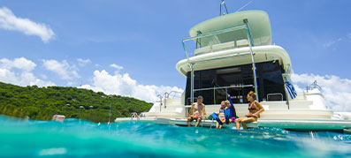 Family sitting on back of charter with legs in the water