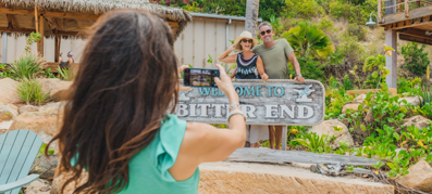 woman taking a picture on her phone of people behind a sign