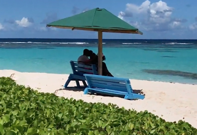 People sitting under an umbrella on a beach
