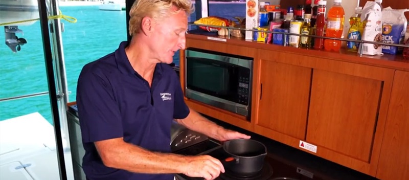 Man cooking on power catamaran