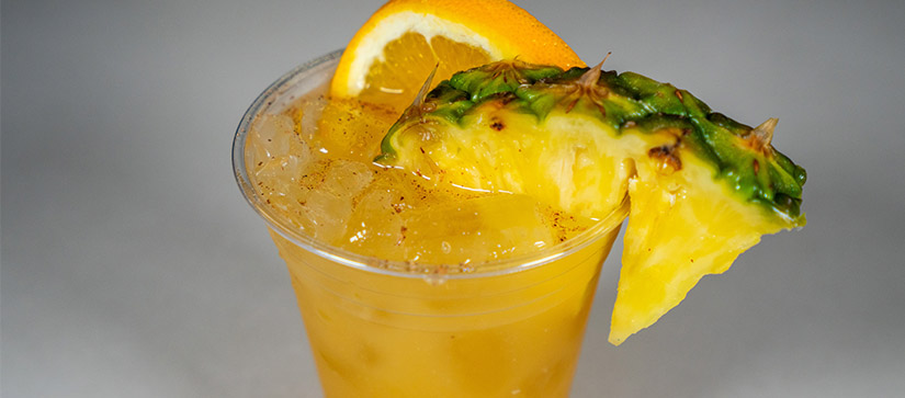 orange drink in a cup with a pineapple