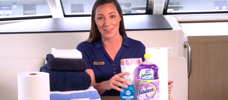 Woman showing cleaning supplies aboard power cataraman