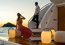 a man and woman looking off of the stern of a yacht