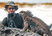 man photographing iguana in golapagos islands