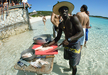 man preparing fish on edge of water in abacos islands