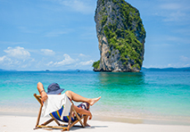 person sitting on beach by the water in thailand