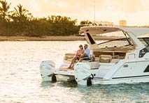 man and woman sitting on back of a boat in the water