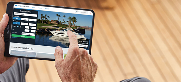 Man looking at yachts on tablet