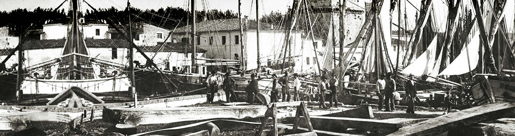 old black and white photo of the original Benetti shipyard with workers standing among pieces of ships and wood
