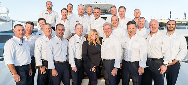 A group of yacht brokerage consultants smiling on a dock.