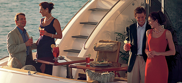Couples enjoying evening drinks aboard yacht