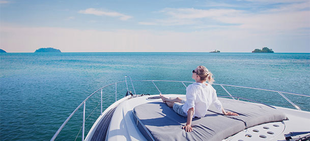 Woman sitting on boat deck, staring into the horizon.