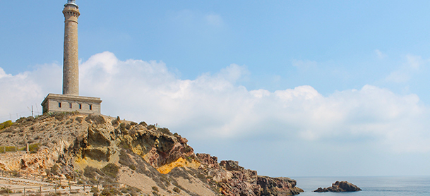 A stone lighthouse looks out off a rocky coast