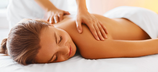 A woman lays down while getting a back massage