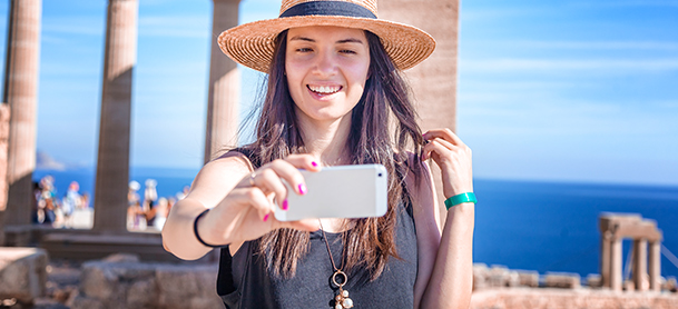 Man in hat taking selfie by columns