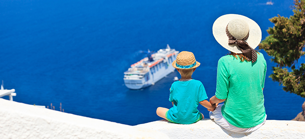 Woman and child sitting along edge, looking down at boat in water