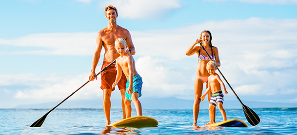 Family paddleboarding. Mom with one child and dad with the other.