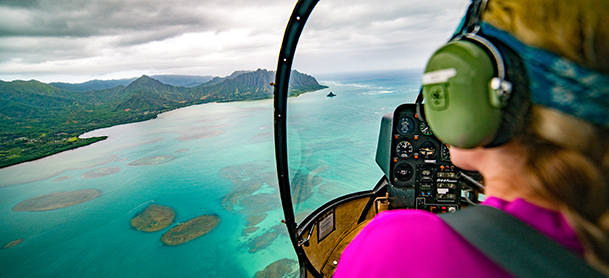 Woman overlooking clear blue water from helicopter