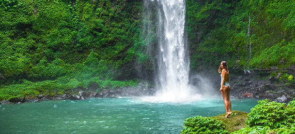 Woman standing by waterfall