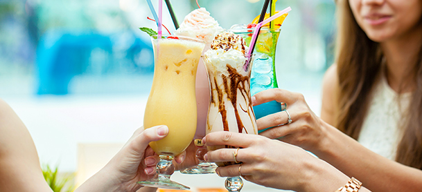 Hands coming together toasting various frozen cocktails