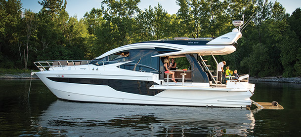 A profile shot of a Galeon yacht with a family standing on it