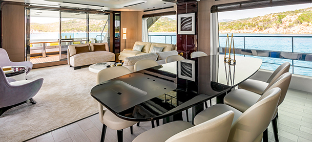 chairs around a table on board a yacht with water in the background