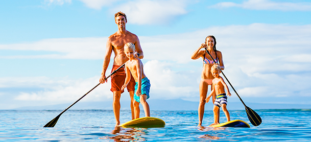 family on stand up paddle boards on open water